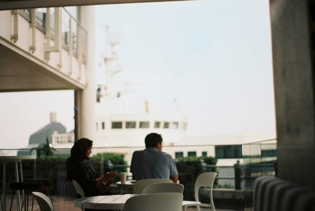 Two people sit with their backs to watch and look at the sea
