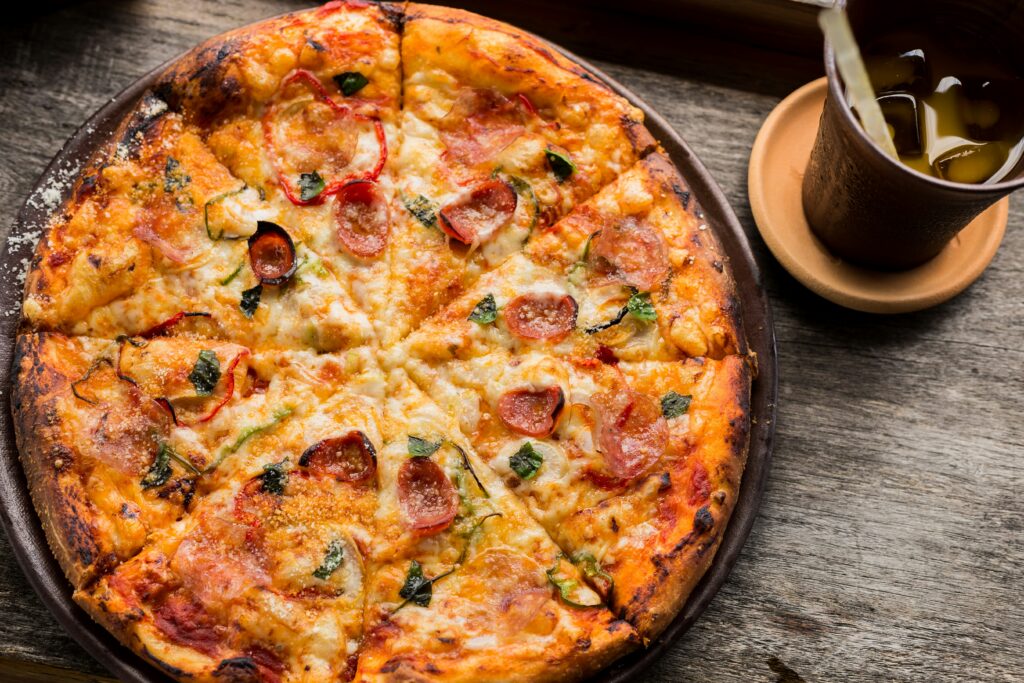 New York-style pizza on a plate with a tee cup nearby