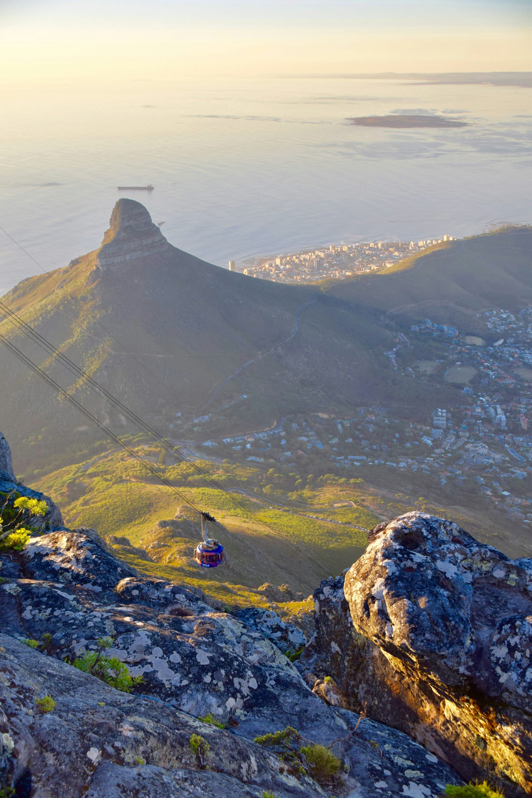 A scenic aerial view of Cape Town, South Africa, featuring the iconic Lion's Head mountain bathed in warm sunlight