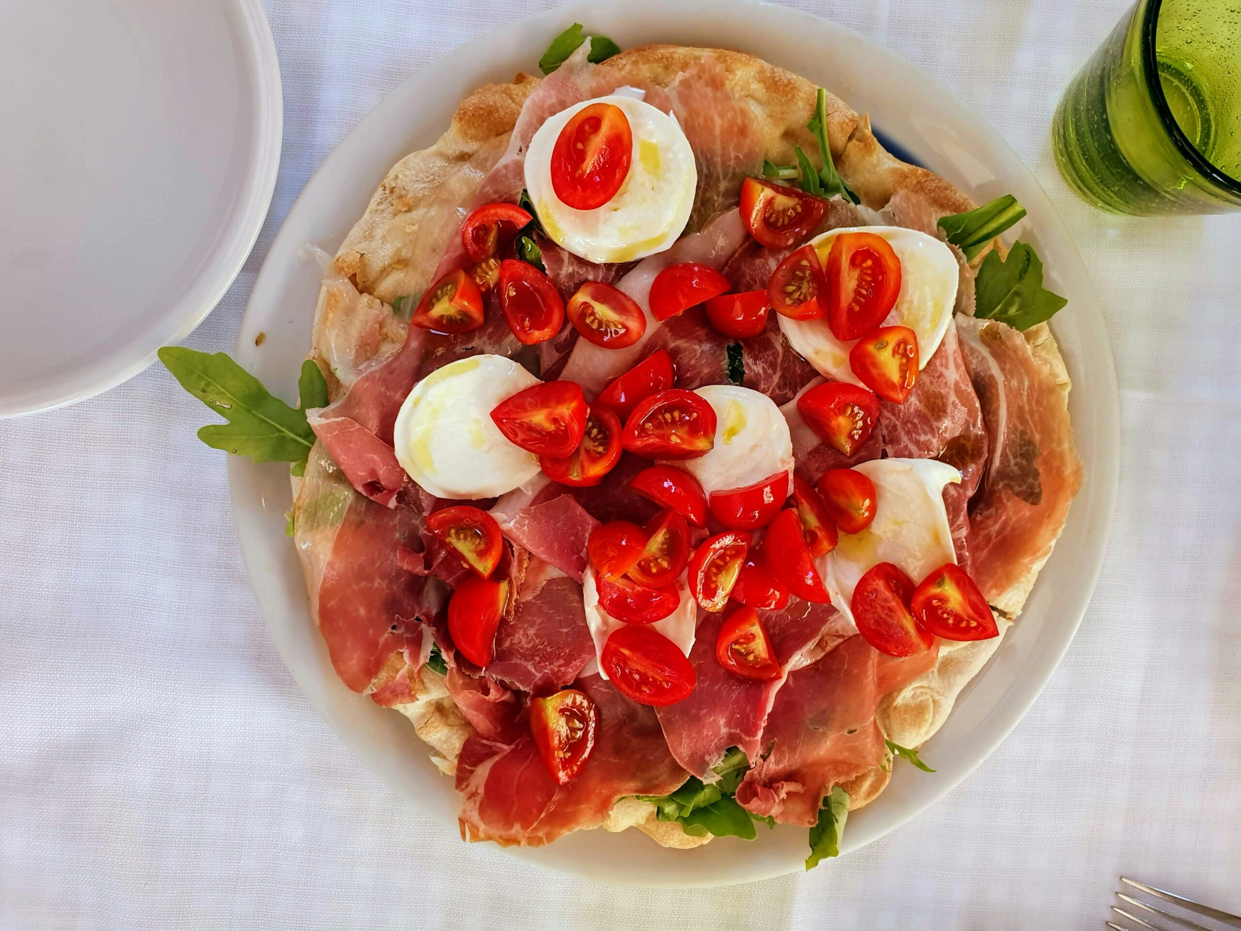 A pizza from above with lots of fresh tomatoes and mozzarella