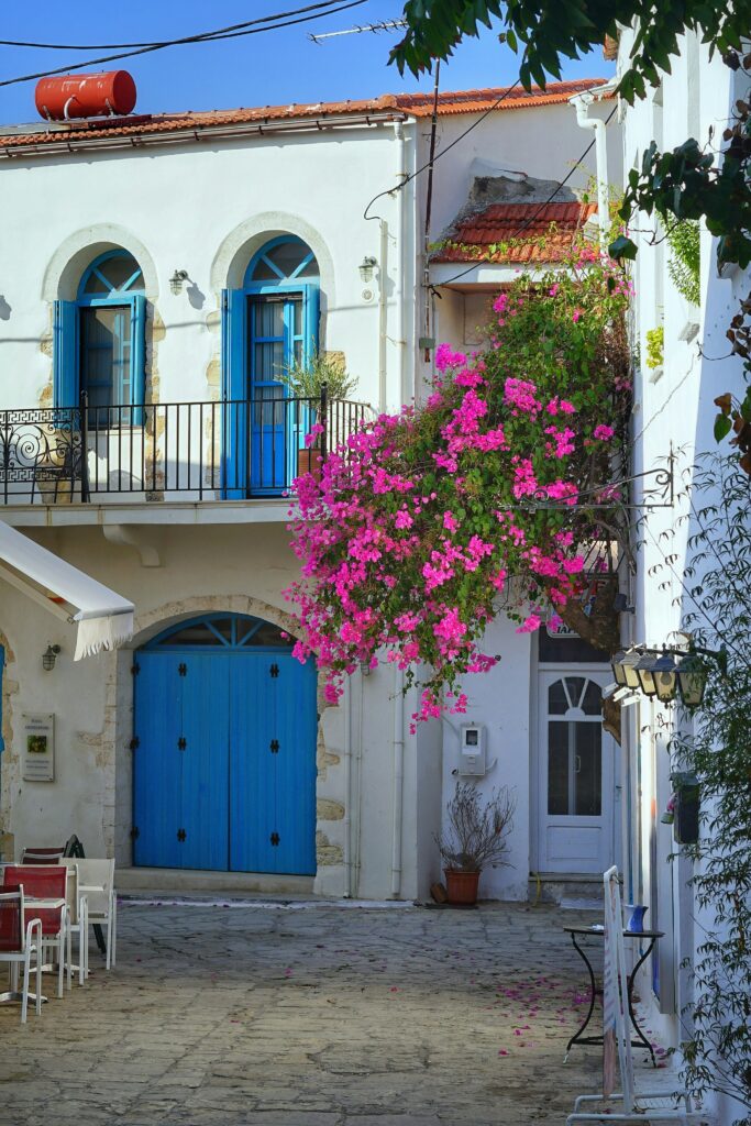 Courtyard in Crete with white houses and a tree with pink blossoms