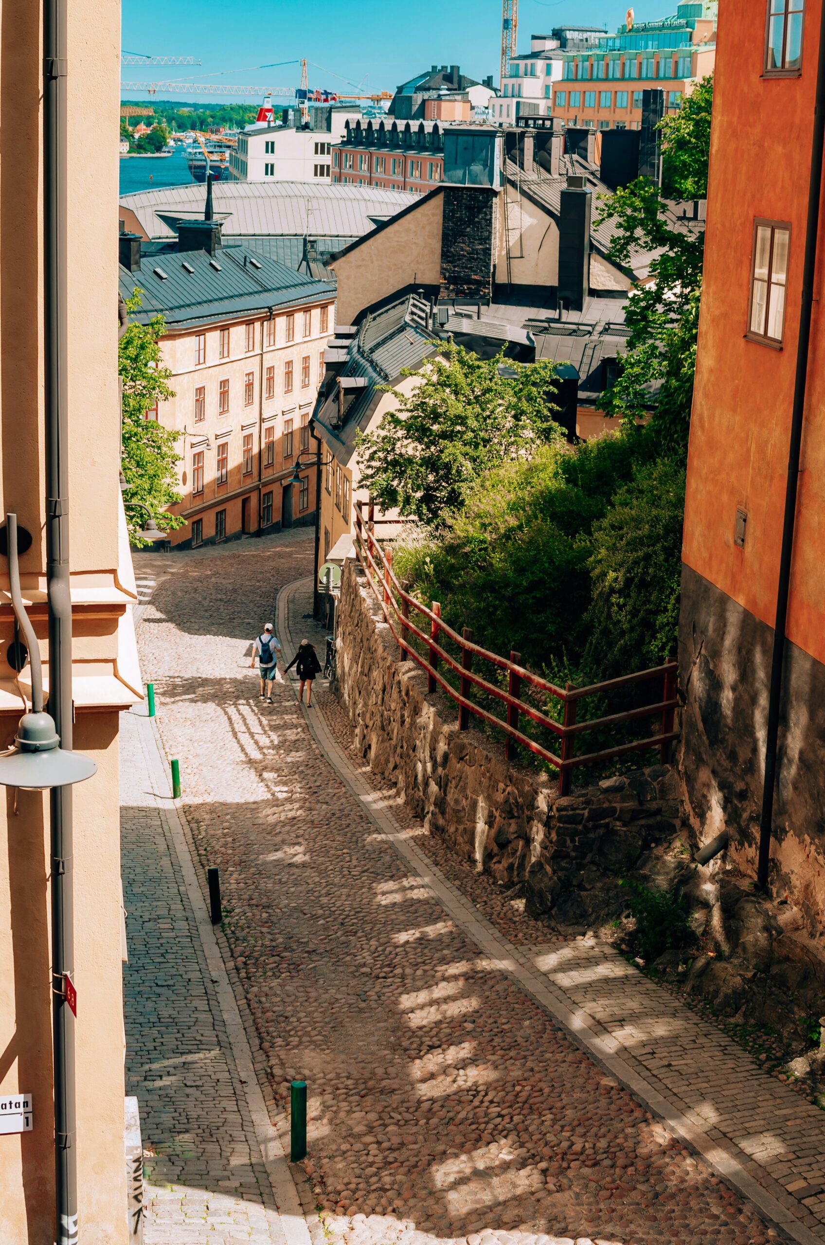 Two people walking along beautiful and old street of Stockholm, perspective from above